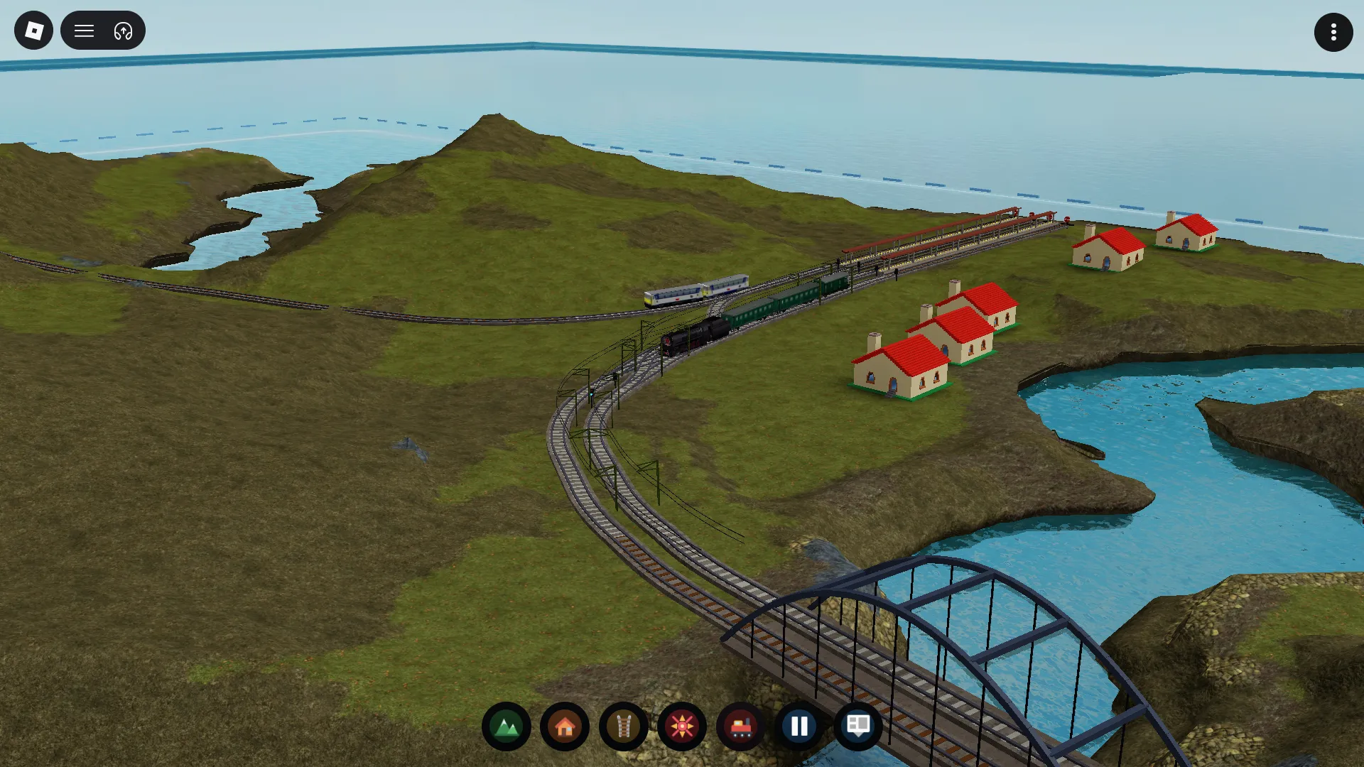 A coastal village sits beside a branching railway and a river crossing.